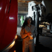 Mechanic performing emergency roadside repair on a truck under low-light conditions.